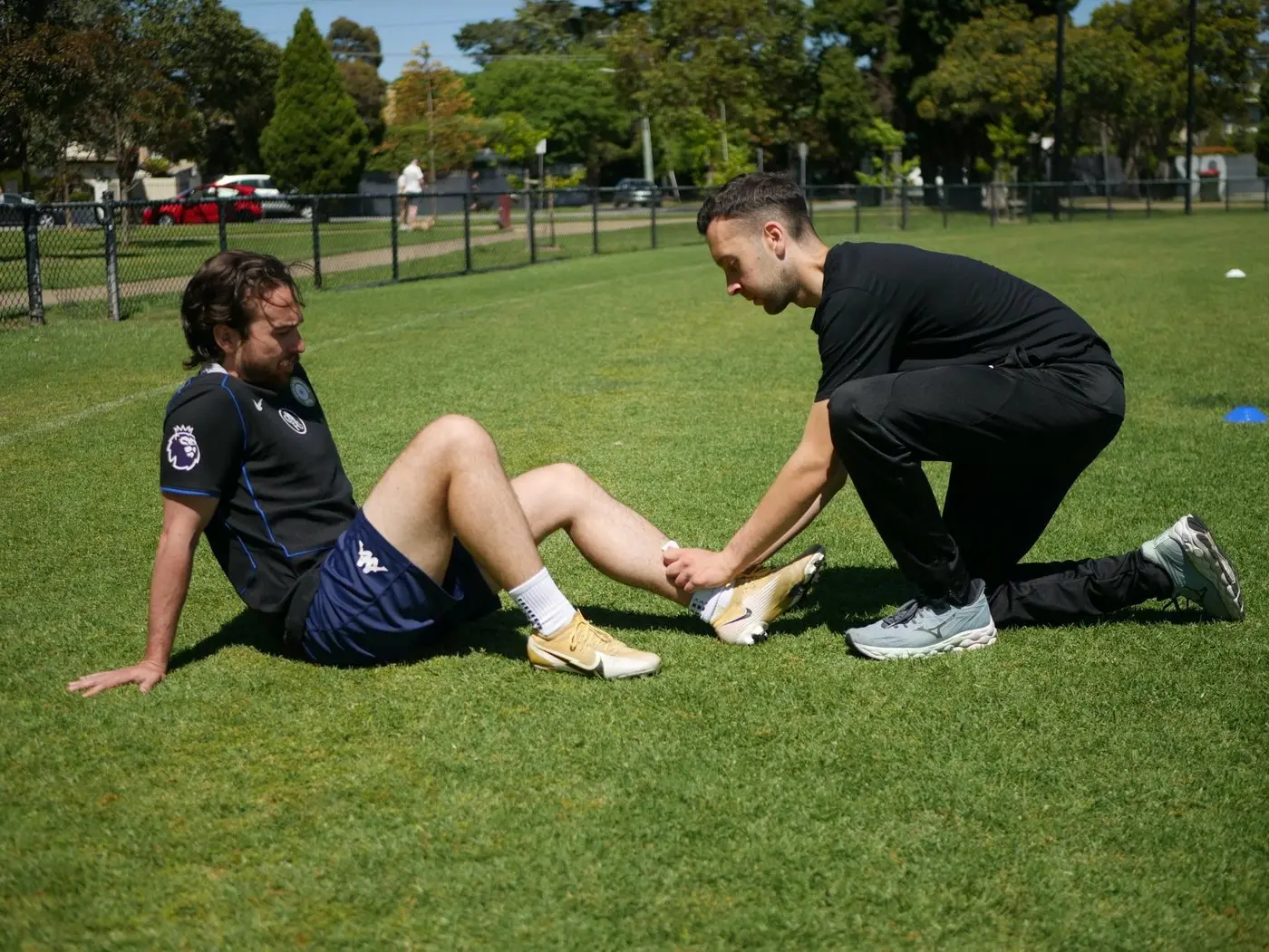 Jake assessing a footballer's ankle on the field