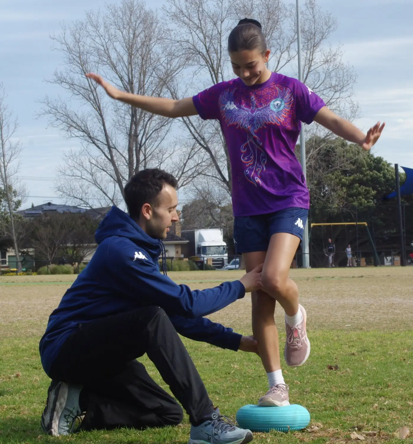 Jake guiding a young footballer through a single-leg balance exercise